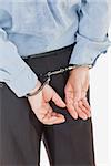 Rear view of businessman in handcuffs standing isolated over white background