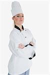 Portrait of confident female chef in uniform standing with arms crossed over white background