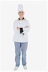 Full length portrait of happy chef standing with arms crossed over white background