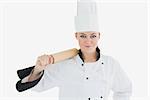 Portrait of female chef holding rolling pin over white background