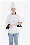 Portrait of happy female chef holding rolling pin against white background