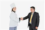 Happy businessman and female chef shaking hands over white background