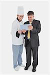 Full length of businessman and chef using digital tablet over white background