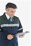 Mature repairman reading notes on clipboard against white background