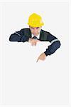 Portrait of repairman pointing at billboard against white background