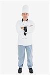Full length portrait of mature chef with arms crossed against white background