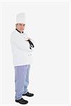 Portrait of mature male chef with arms crossed standing over white background