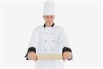 Male mature chef holding rolling pin over white background