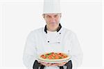 Portrait of mature male chef holding pizza over white background