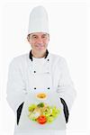 Portrait of happy male chef displaying fresh prepared meal over white background