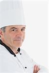 Portrait of confident male chef with arms crossed against white background
