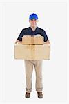 Portrait of delivery man carrying stack of cardboard packages against white background