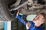 Male mechanic with flashlight examining tire