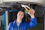 Portrait of auto mechanic repairing car with adjustable pliers