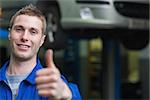 Portrait of smart car mechanic gesturing thumbs up in workshop