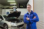 Portrait of confident male mechanic with spanner in workshop