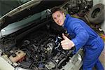 Portrait of car mechanic gesturing thumbs up in workshop