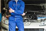 Male mechanic in front of car with open hood