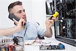 Young computer engineer working on cpu while on call at workplace