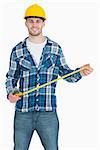 Portrait of smiling young male architect with tape measure over white background