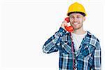 Portrait of young male architect using landline phone over white background