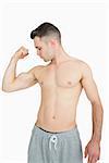 Shirtless young man flexing muscles over white background