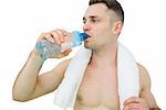 Young shirtless man drinking water with towel around neck over white background