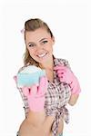 Portrait of happy young woman holding soap suds over sponge against white background