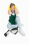 Tired maid screaming as she sits with brush and dust pan over white background