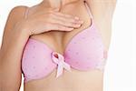 Closeup of woman in bra with breast cancer awareness ribbon over white background