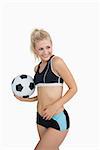 Portrait of happy woman in sportswear with football over white background