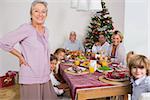 Smiling grandmother standing beside dinner table at christmas