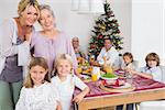 Three generations of women standing by the dinner table at christmas time