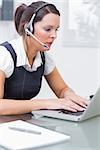 Side view of young business woman wearing headset in office