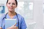 Portrait of young female surgeon holding digital tablet at clinic