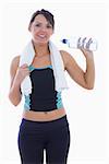 Portrait of young woman in sportswear drinking water over white background