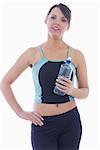 Portrait of young woman in sportswear holding water bottle over white background