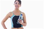 Portrait of young woman in sportswear holding water bottle over white background