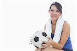 Portrait of happy woman in sportswear holding football over white background