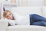 Portrait of casual young woman lying on sofa at home