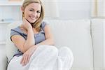 Portrait of relaxed young woman sitting on couch at home
