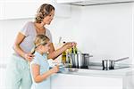 Mother and daughter preparing dinner together in the kitchen