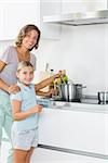Happy mother and daughter cooking together in the kitchen