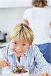 Smiling boy in kitchen having breakfast