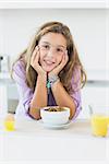 Happy girl at breakfast in the kitchen