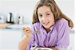 Little girl having cereal for breakfast