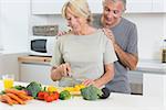 Couple cutting vegetables together in the kitchen