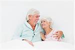 Elderly couple sitting in bed