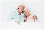 Smiling old couple in bed