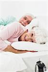 Elderly couple waking up in bedroom